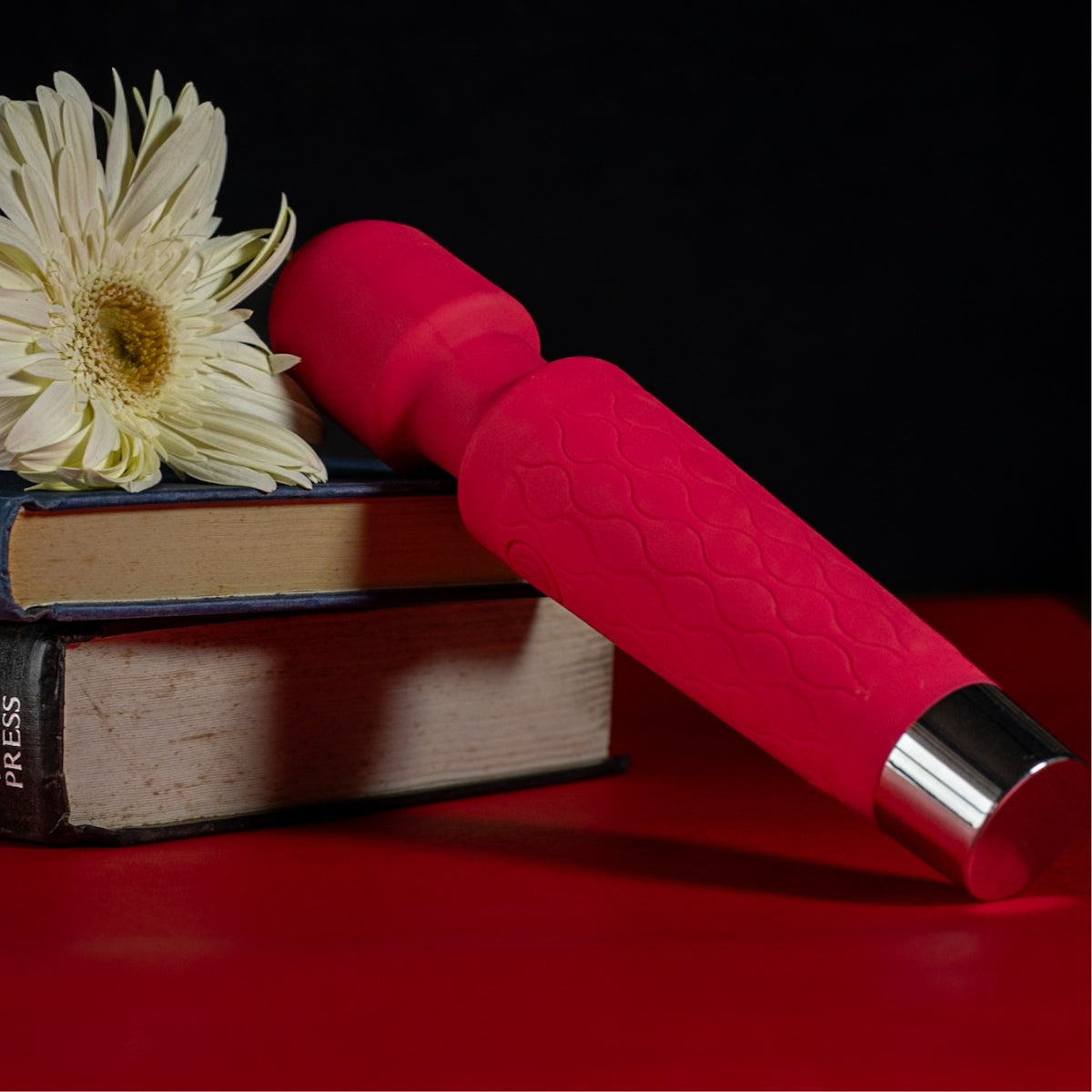 Dione Rouge, wellness massager next to a pile of books, serene atmosphere