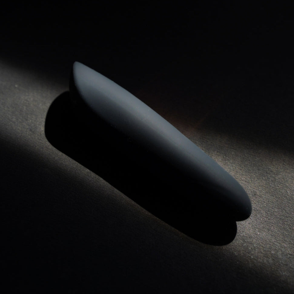 Black silicone bullet massager Dia Mini Noir on a dark textured surface, showcasing its advance discretion and features