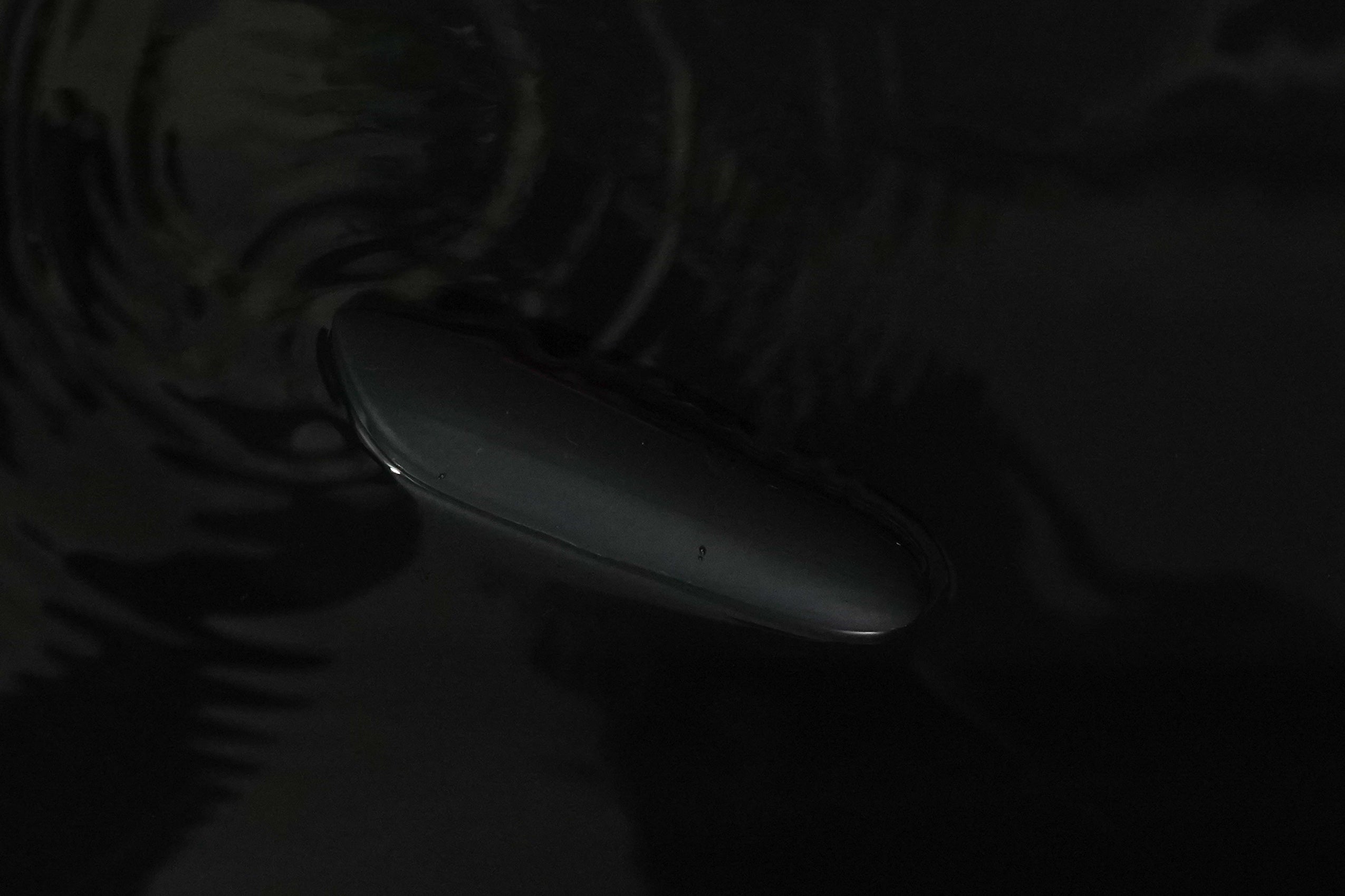 Close-up on a discreet bullet and compact massager with water on the background